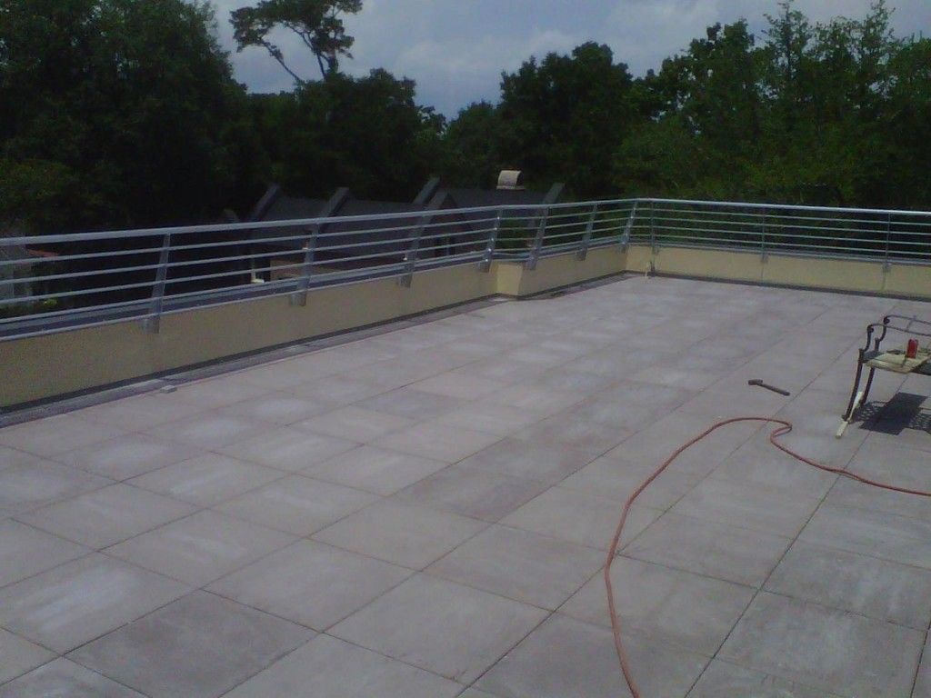 A rooftop with a metal railing and tiles