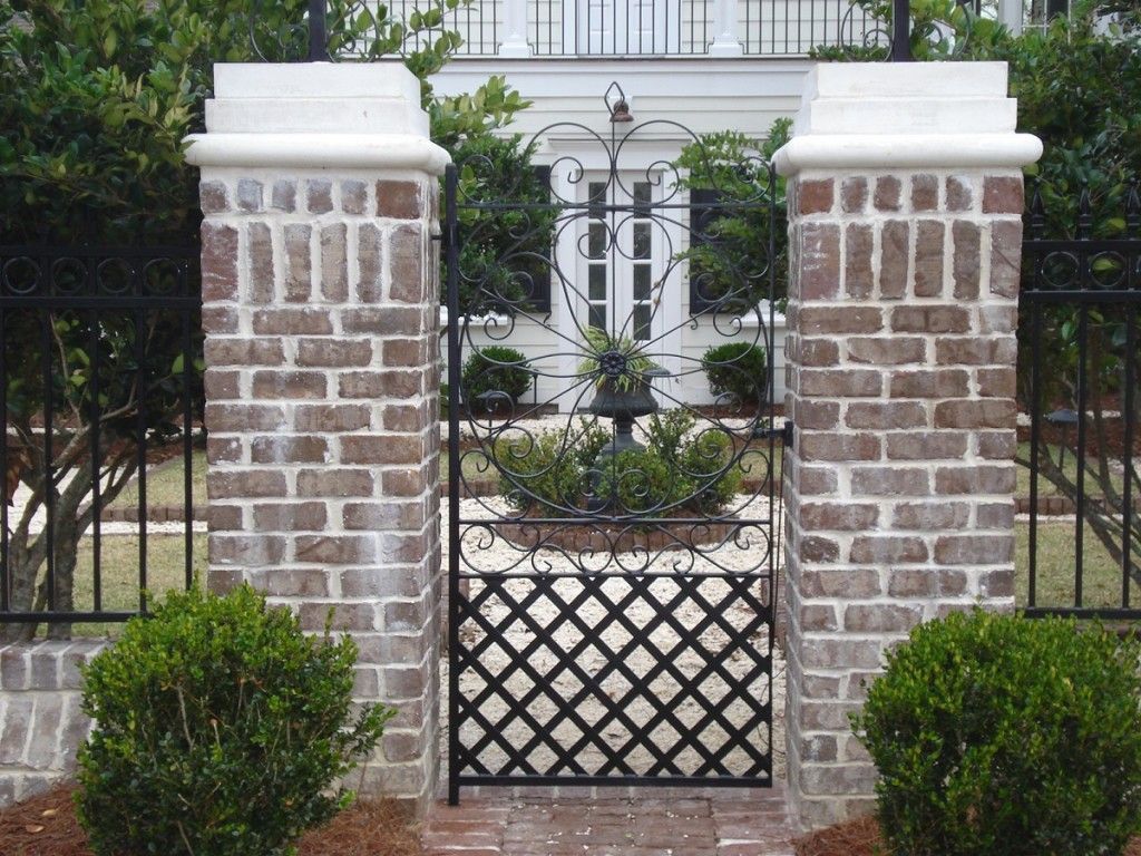 A brick wall with a gate in front of a house