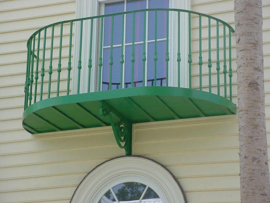 A green balcony on the side of a building