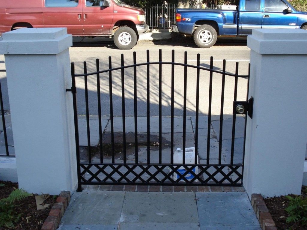A blue truck is parked behind a wrought iron gate