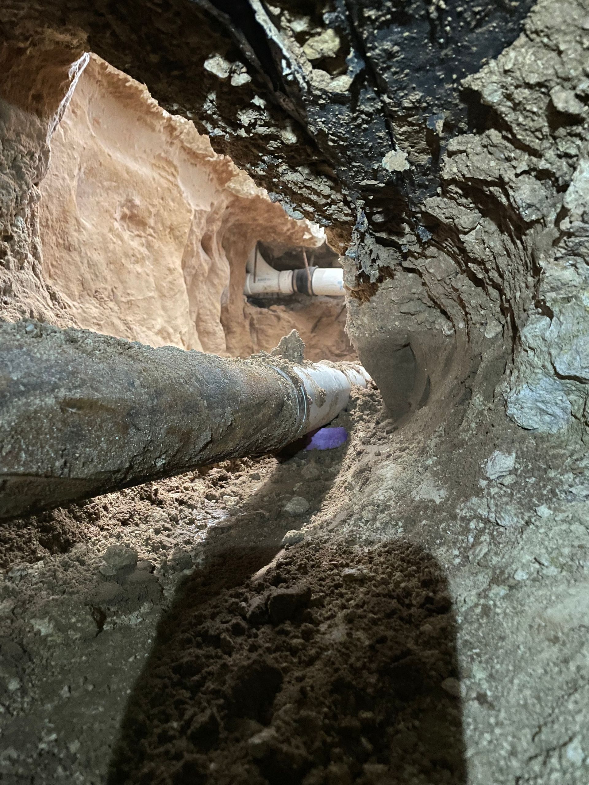 A pipe is coming out of a hole in the ground.