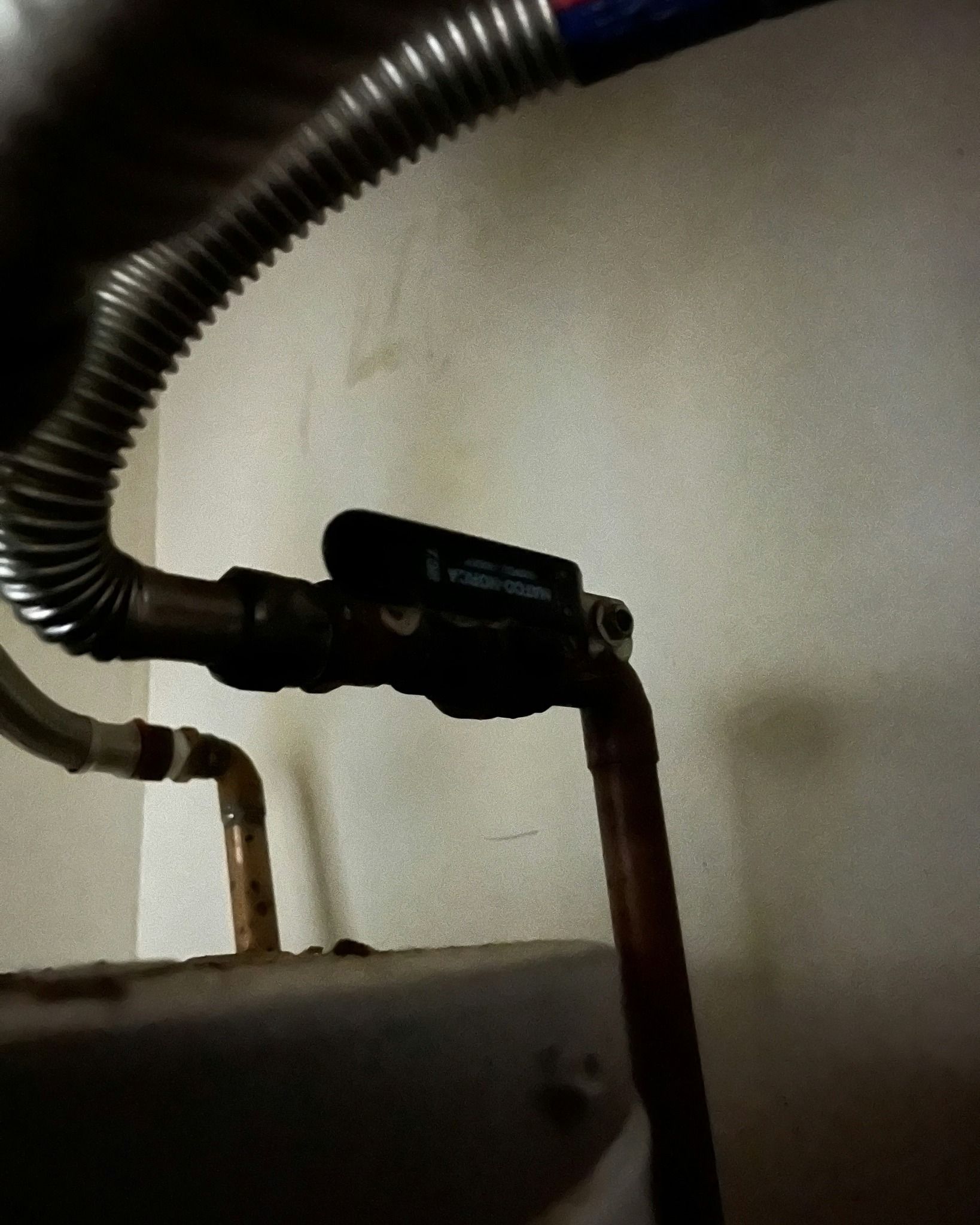 A close up of a pipe with a hose attached to it