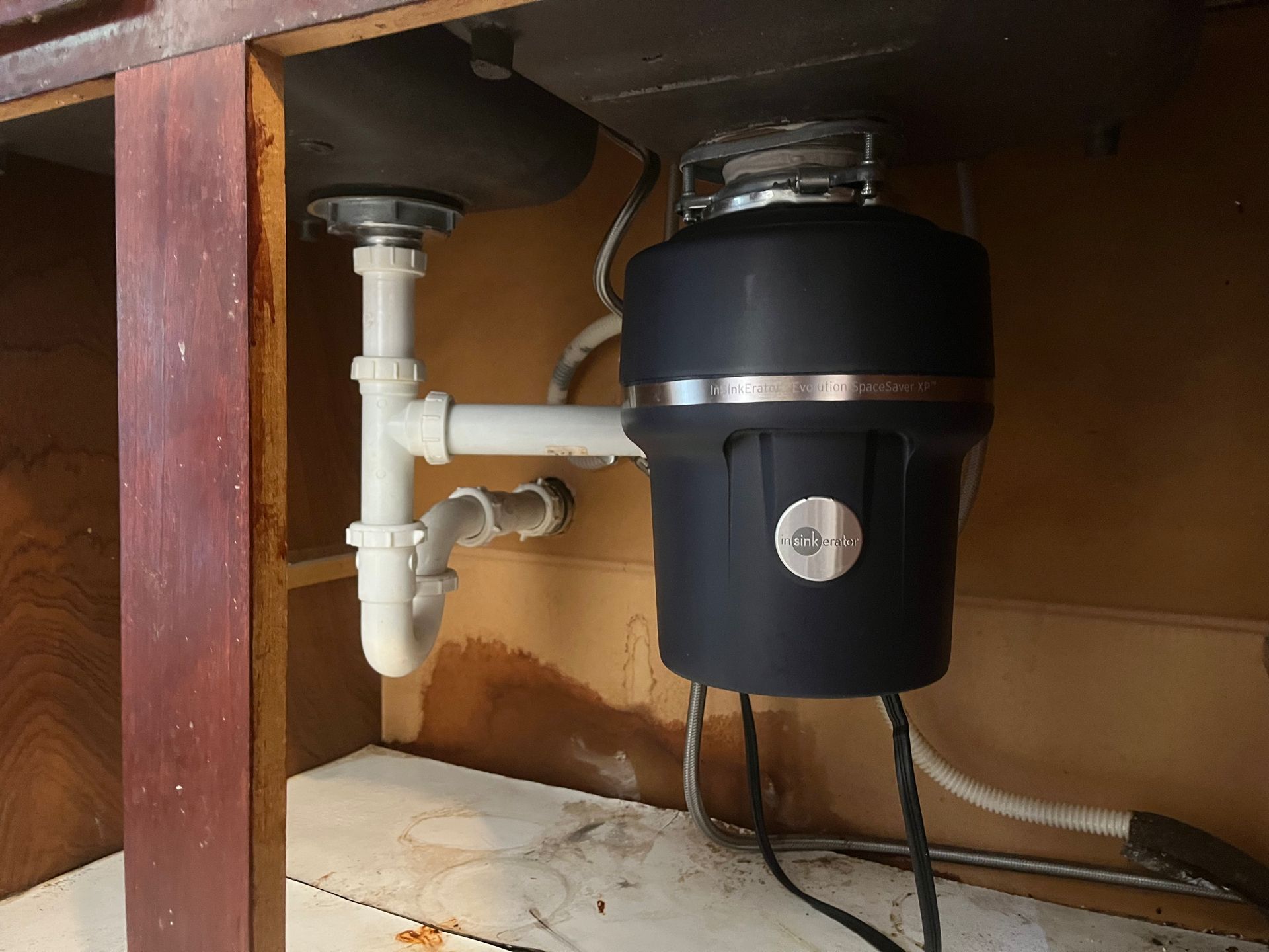 A garbage disposal is sitting under a sink in a kitchen.