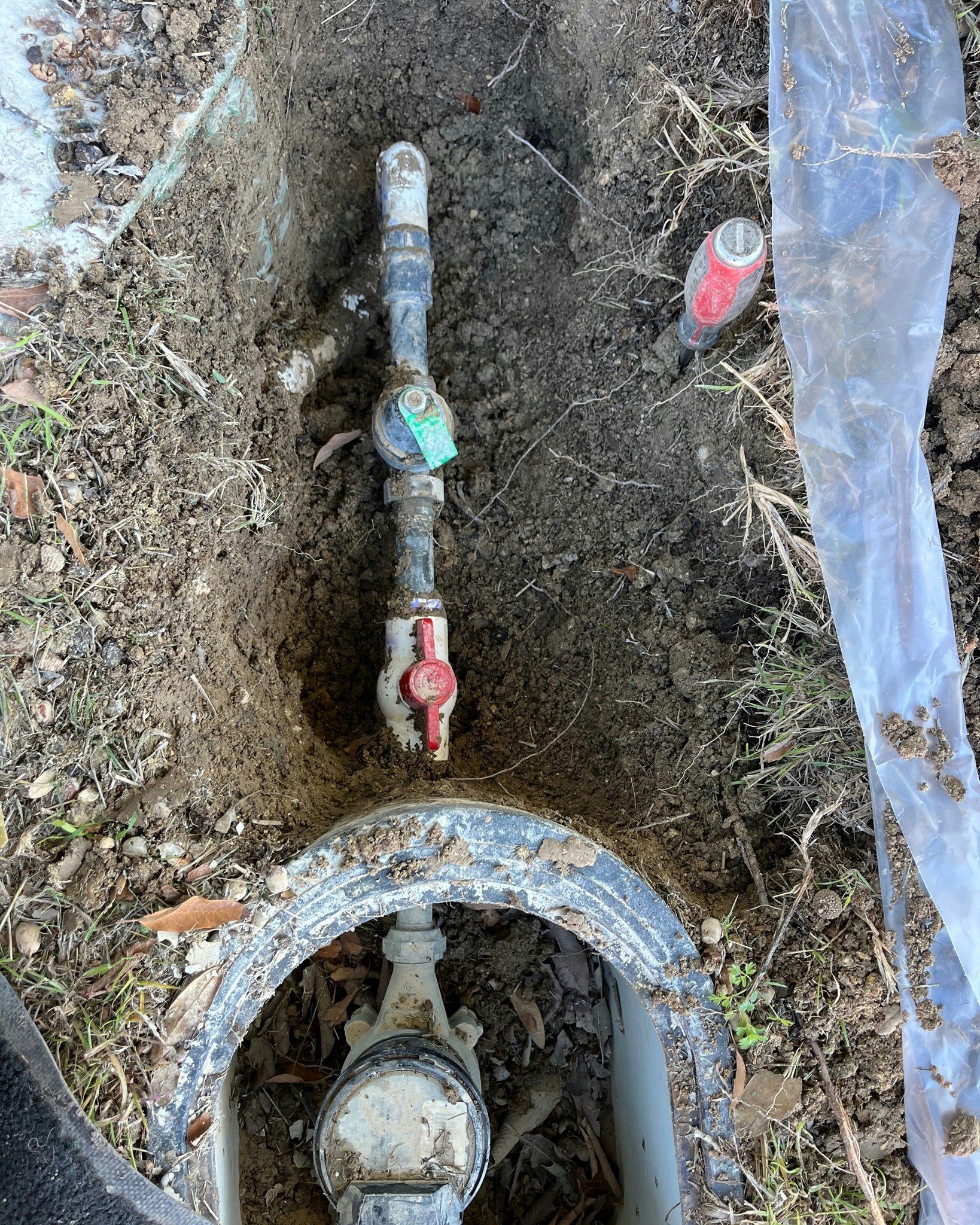 A water meter is sitting in a hole in the ground.