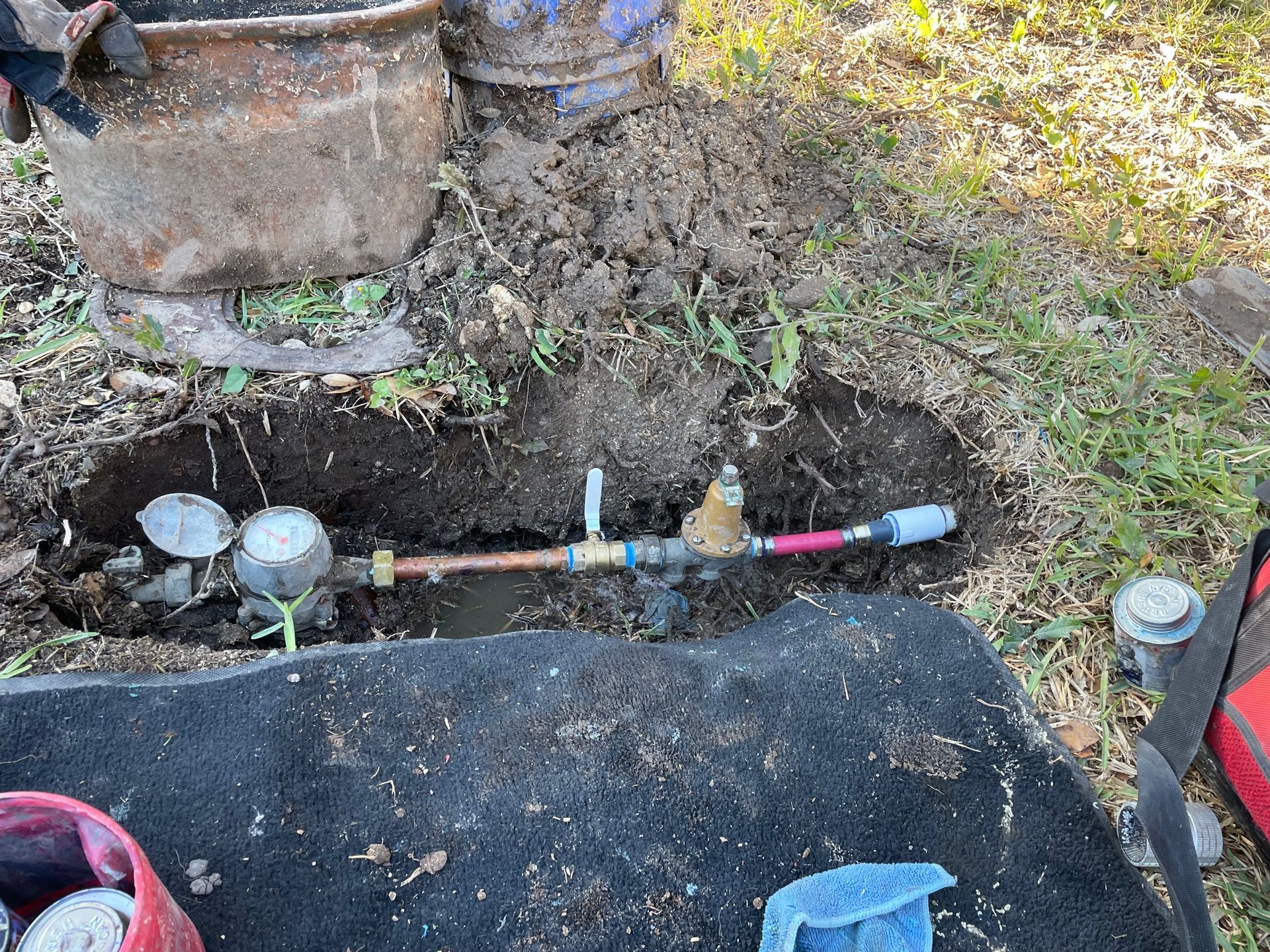 A water meter is being installed in a hole in the ground.