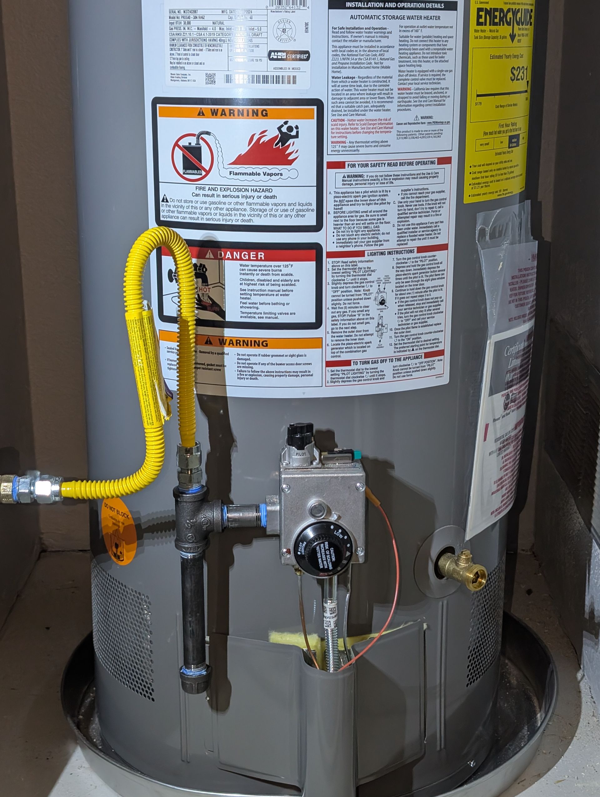 A gray water heater with a yellow hose attached to it