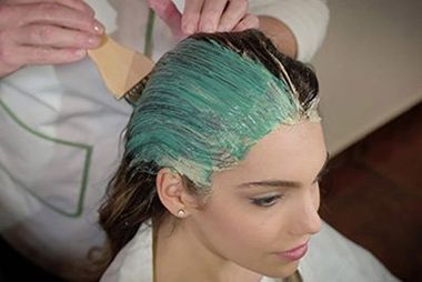 La parrucchiera asciugando i capelli di una donna con il fon a Milano