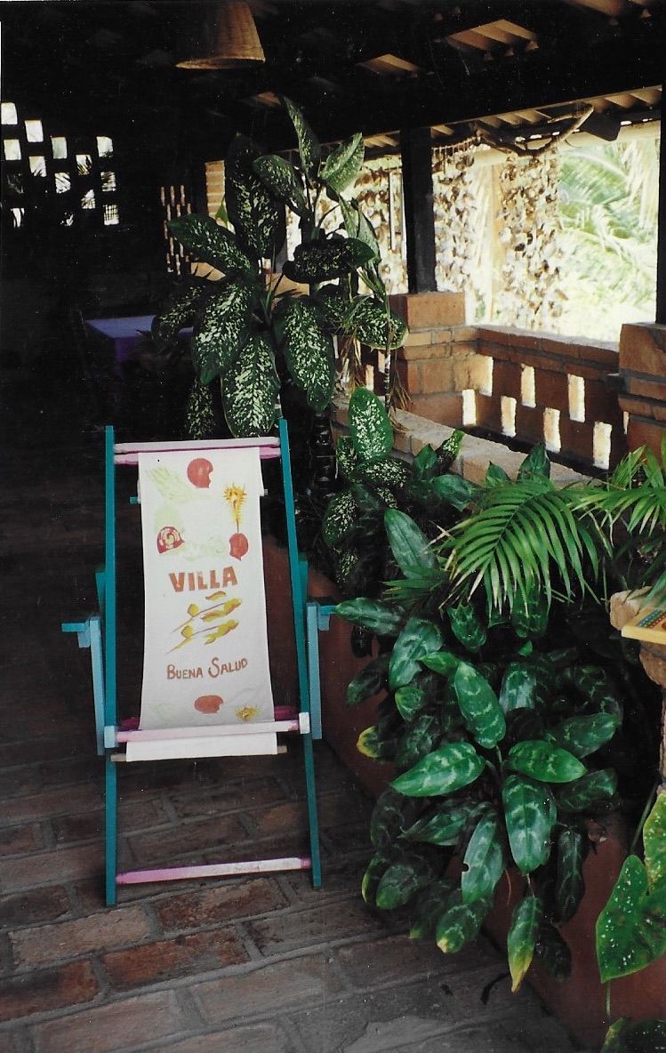 Una silla de playa verde azulado y blanca con la palabra