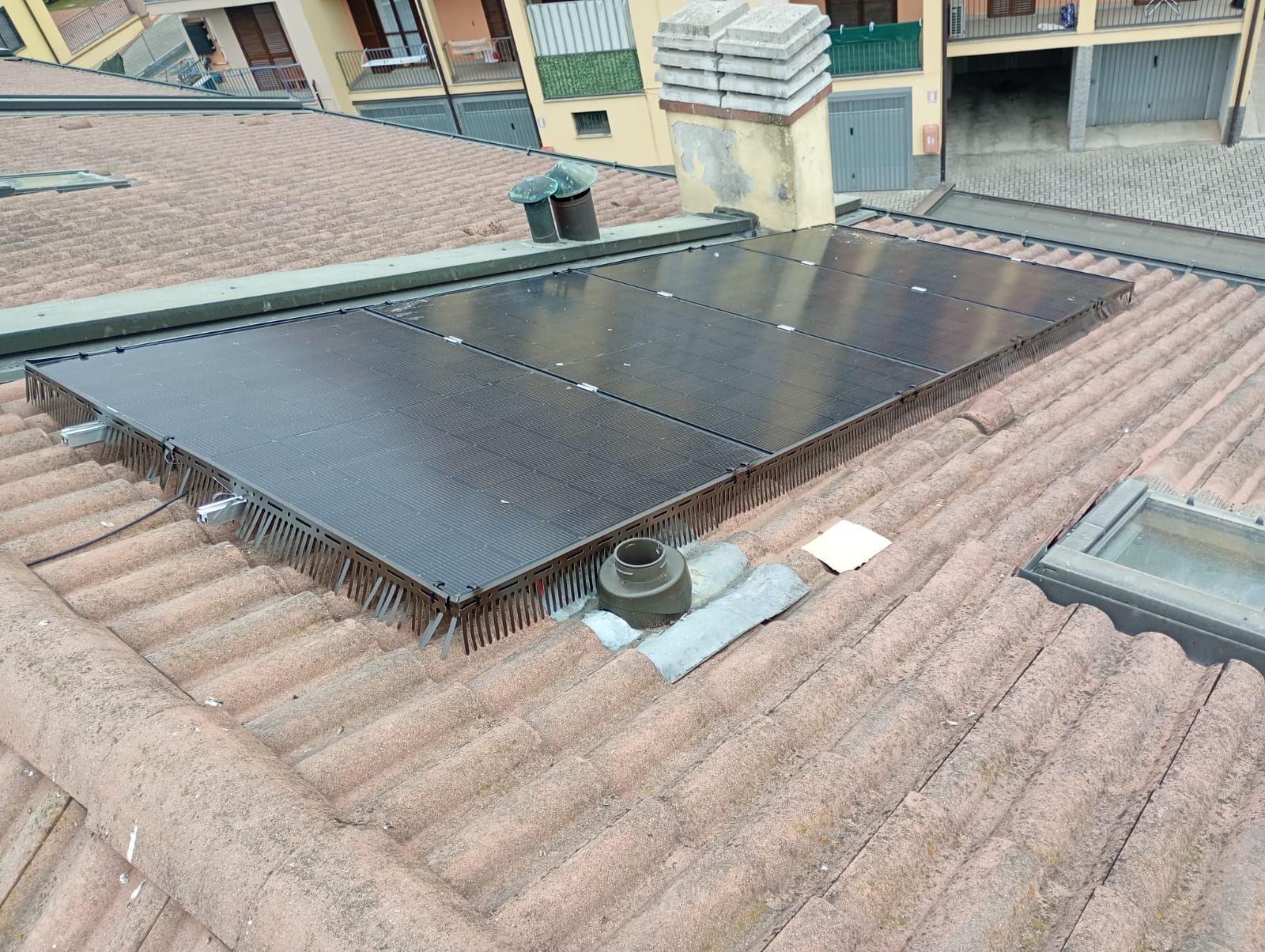 Una fila di pannelli solari su un tetto con le montagne sullo sfondo.