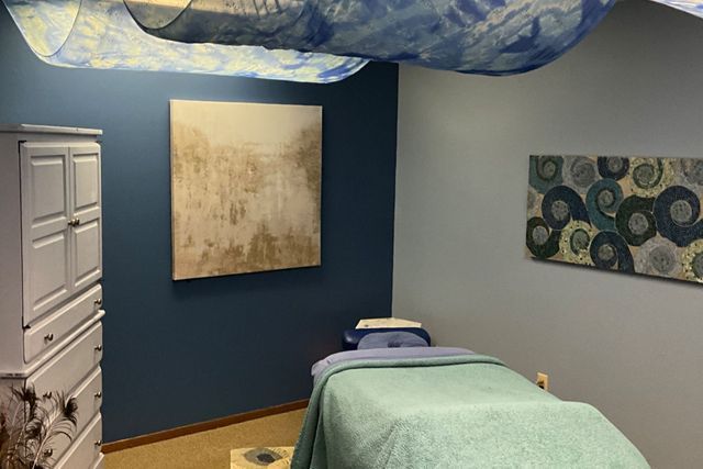 There is a massage table in the middle of the room.