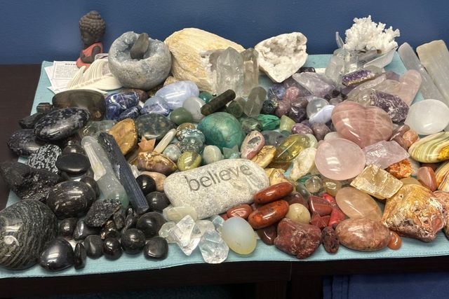 A table topped with a variety of rocks and a rock that says believe.