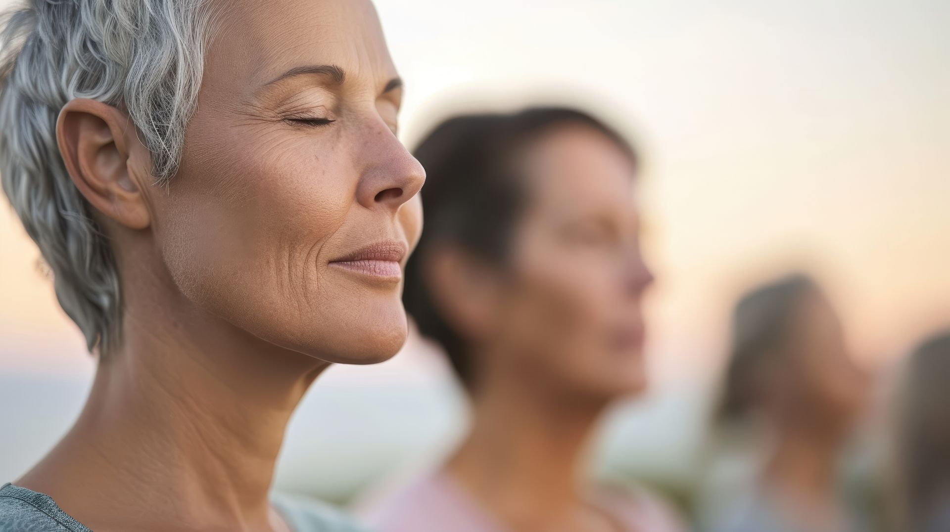 A group of older women are meditating with their eyes closed.