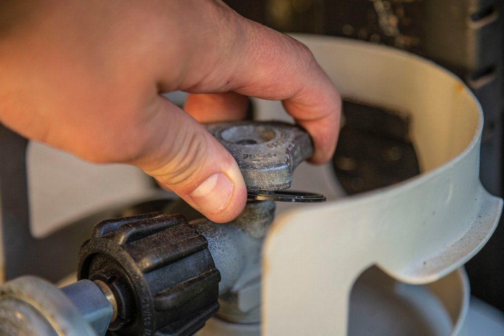 Hand Turning On Gas Propane Grill Tank Knob — Lakeside Gas Fridges In Argenton NSW