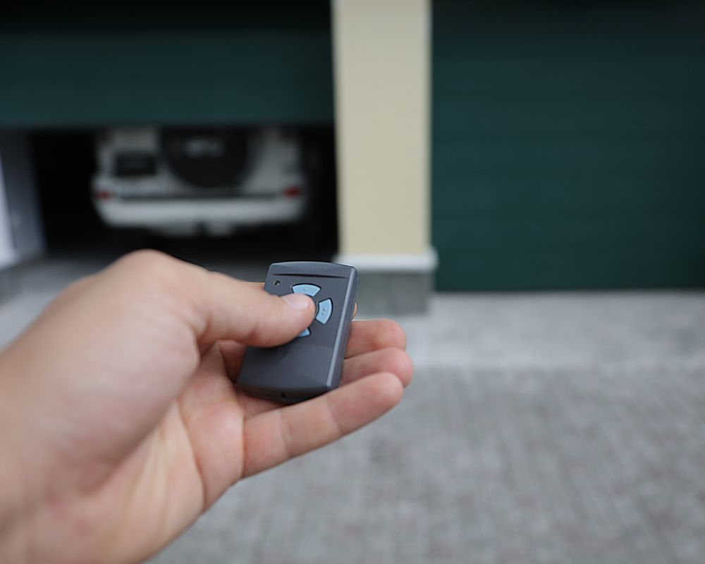 Man Holding Garage Door Remote — Haverstraw, NY — Delco Overhead Door Co
