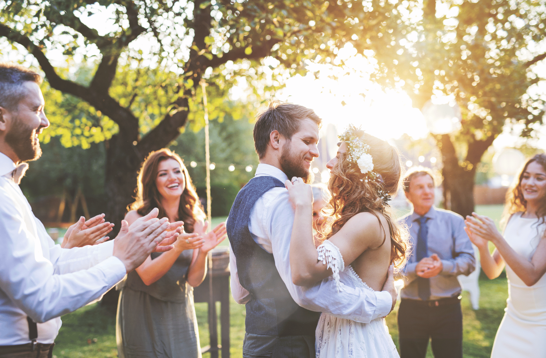 A bride and groom are dancing with their wedding guests at their wedding reception.