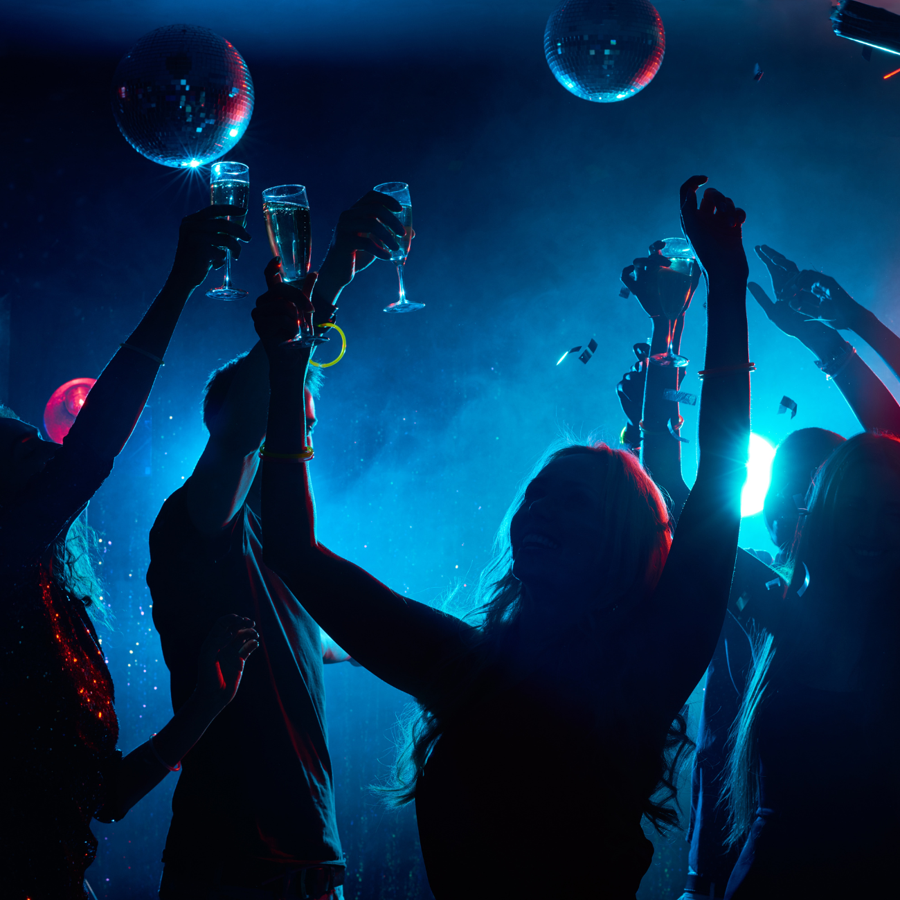 A group of people raising their glasses in the air at a party