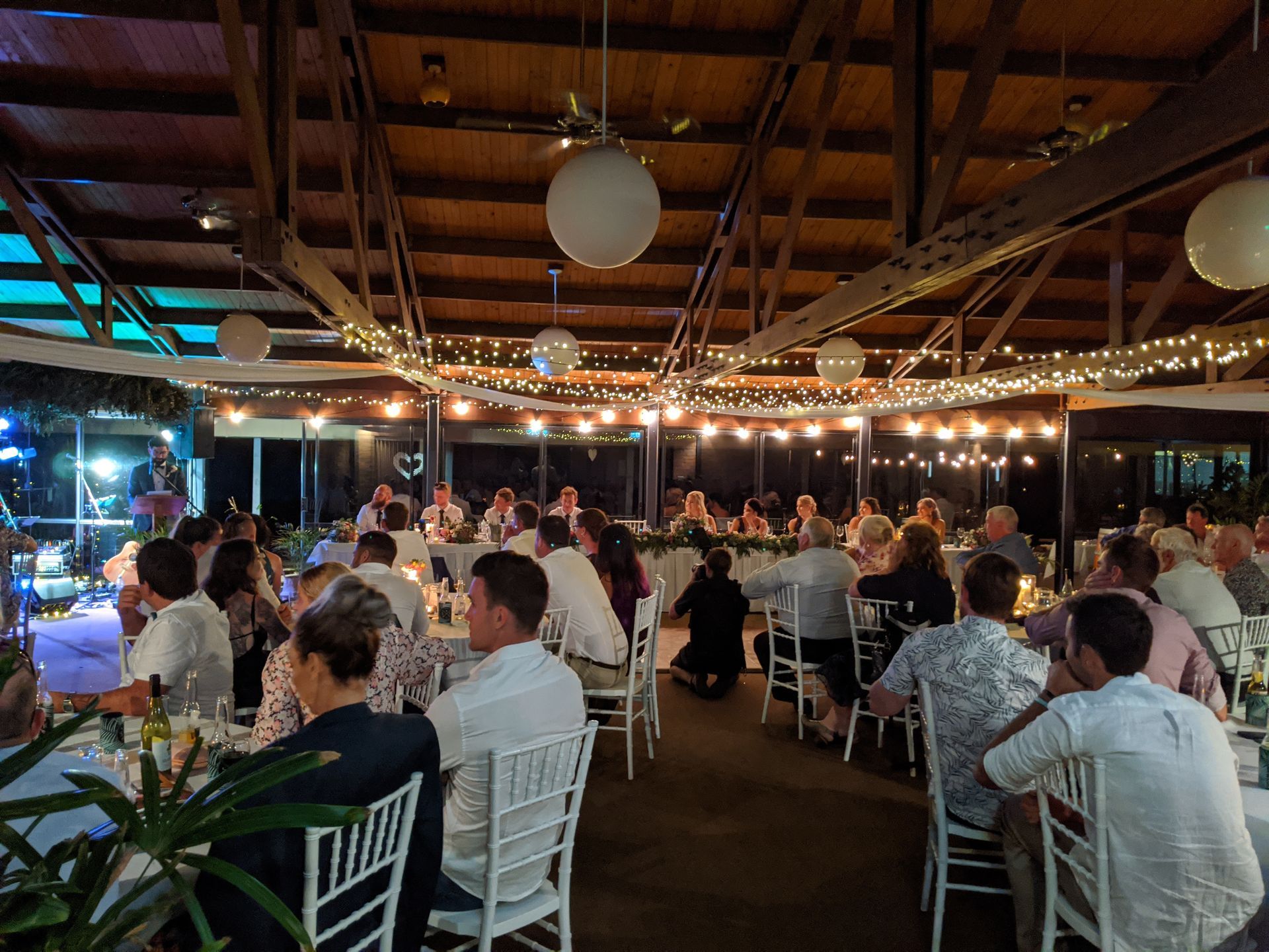 A large group of people are sitting at wedding tables in a restaurant.