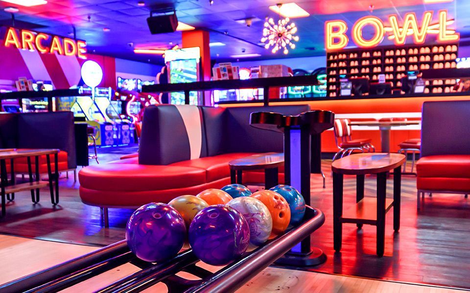A bowling alley with a bunch of bowling balls in it.