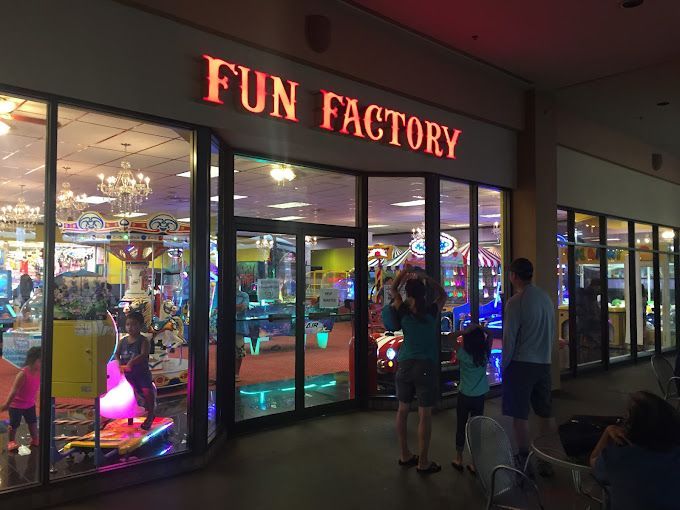 A group of people are standing outside of a fun factory