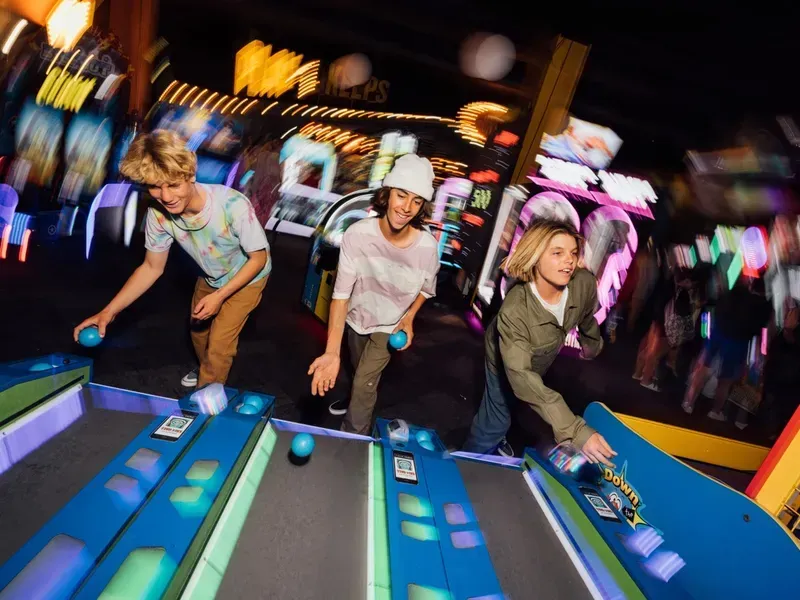 A group of people are playing a game of bowling in an arcade.