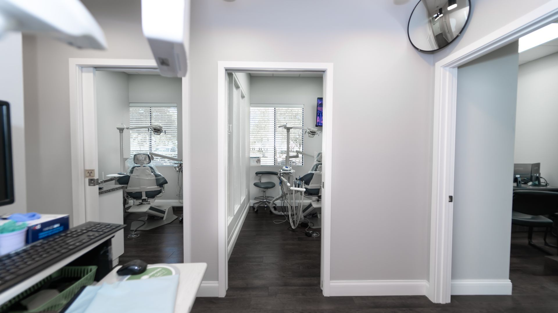 A dental office with a dental chair and a mirror on the wall.