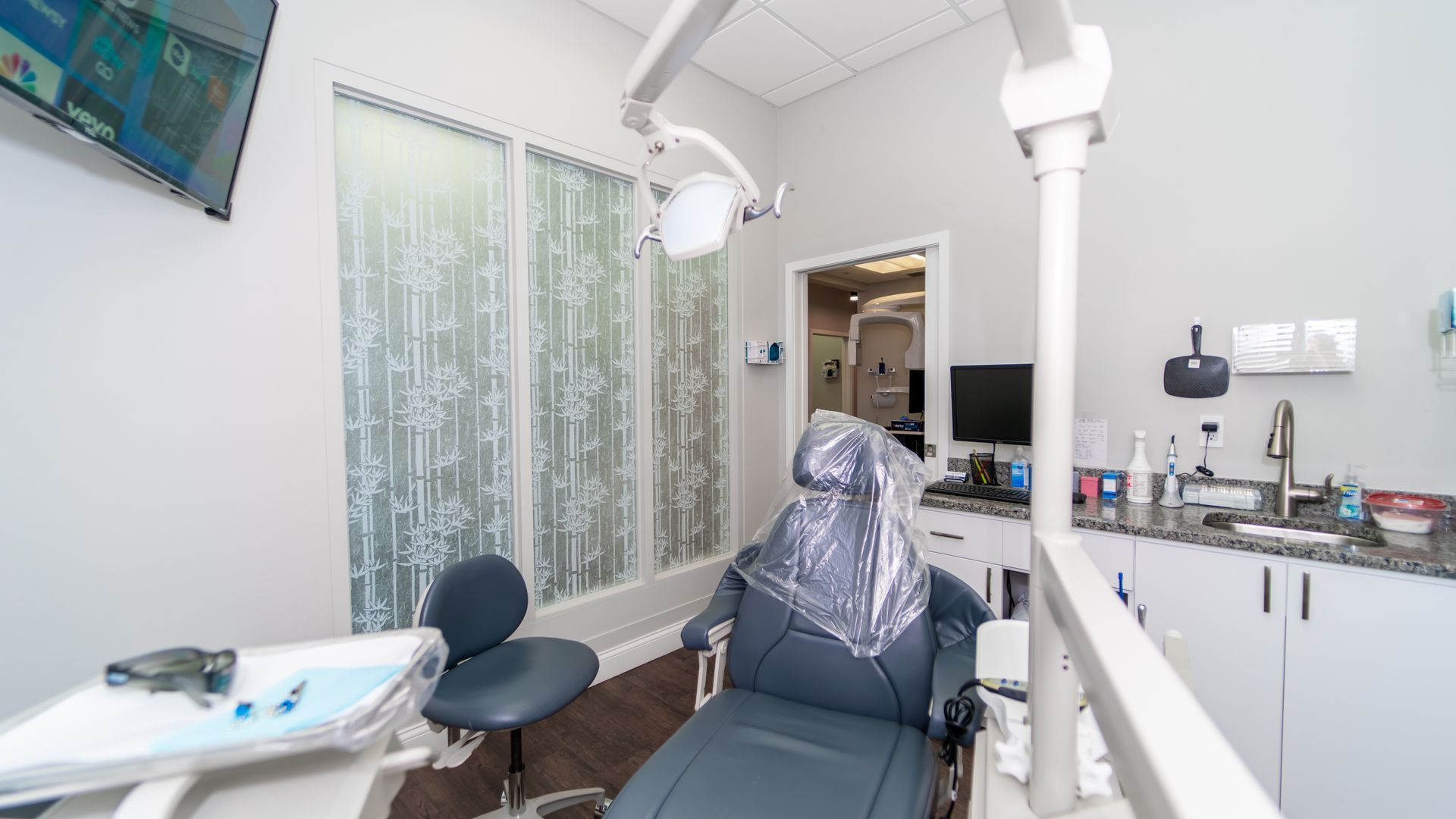 A dental office with a dental chair and a sink.