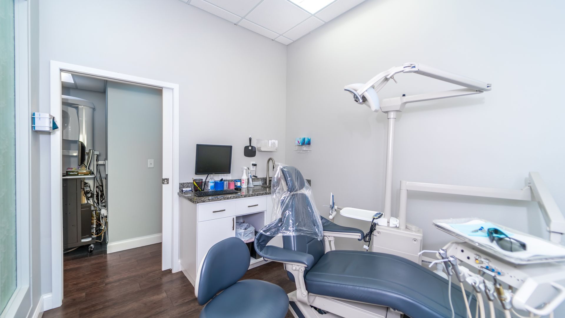 A dental office with a dental chair and a computer.
