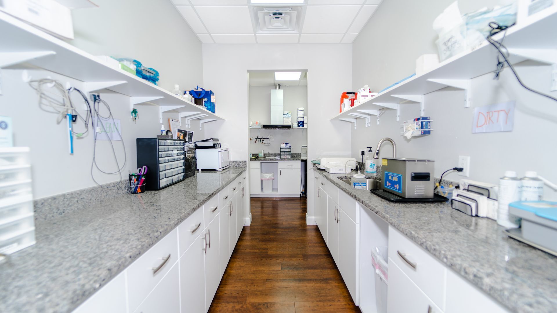 A long narrow room with a lot of shelves and cabinets.