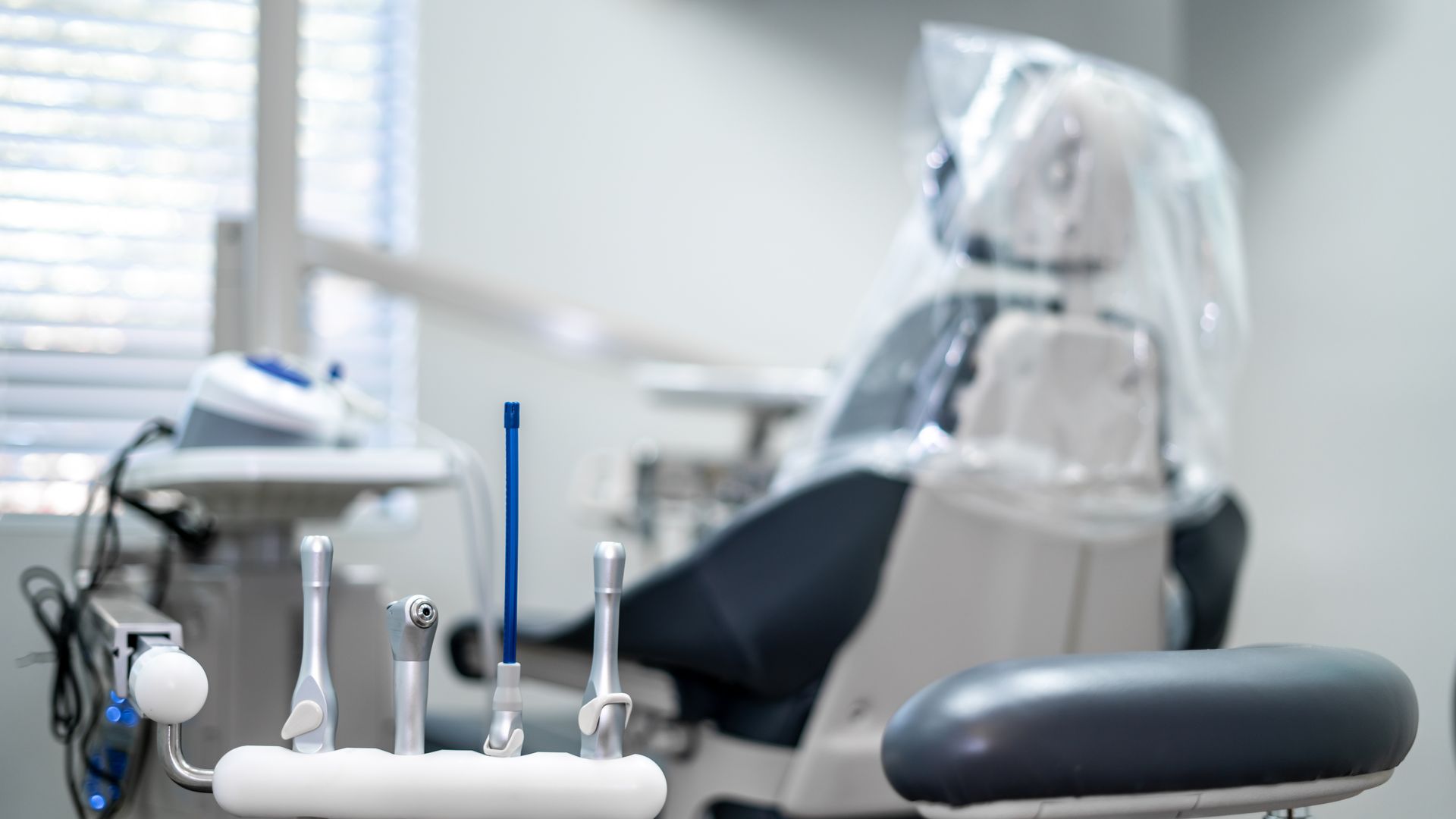 A dental chair with a plastic cover on it in a dental office.