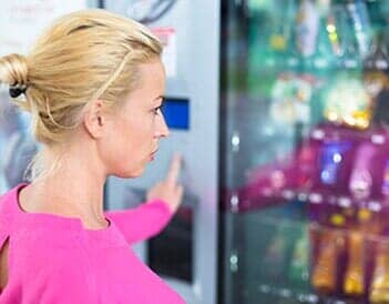 Woman at Vending Machine Purchasing a Snack