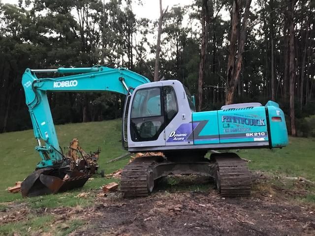 A combine harvester is working in a wheat field at sunset.