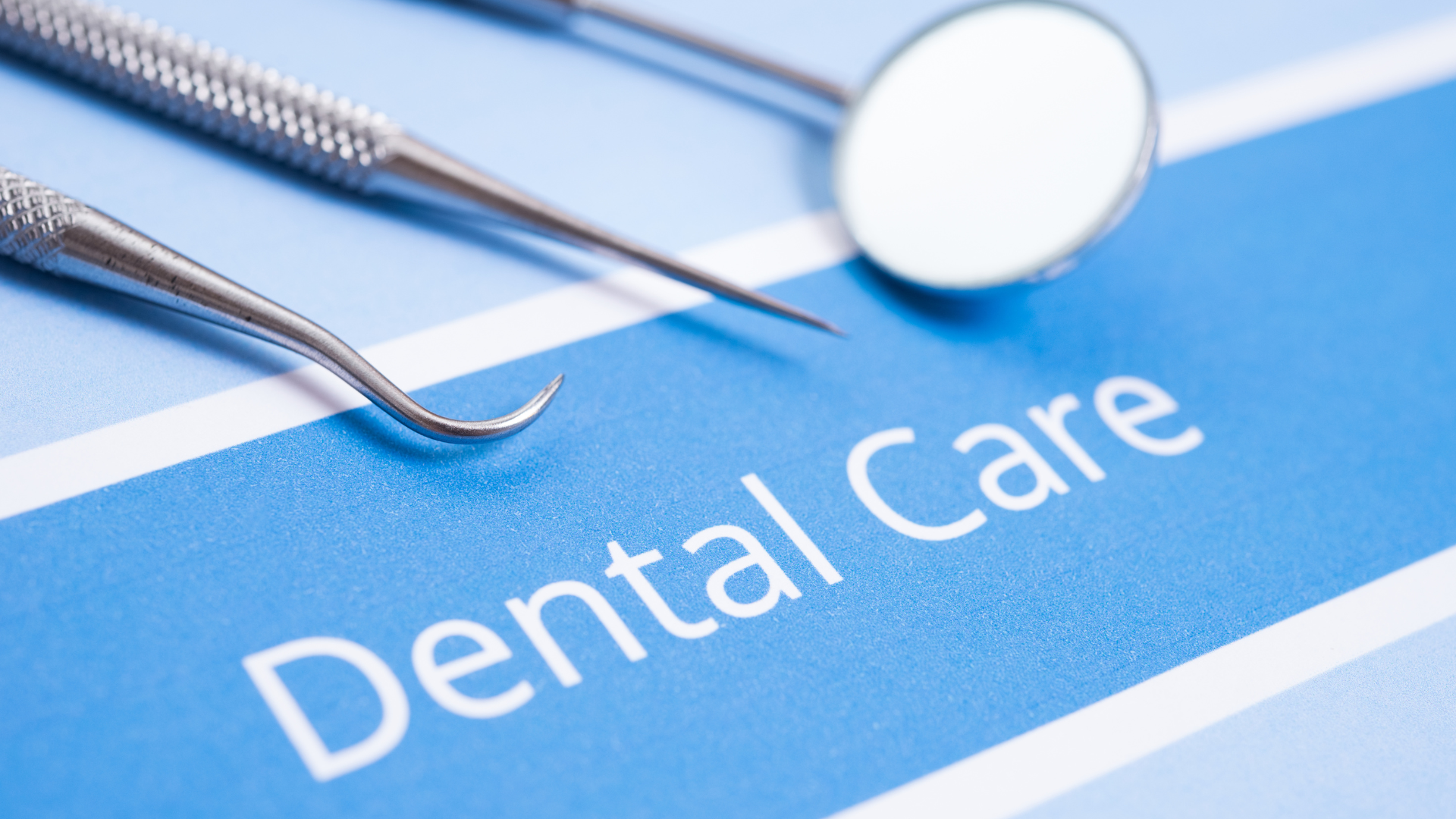 Dental tools (probe, mirror) on blue surface with 