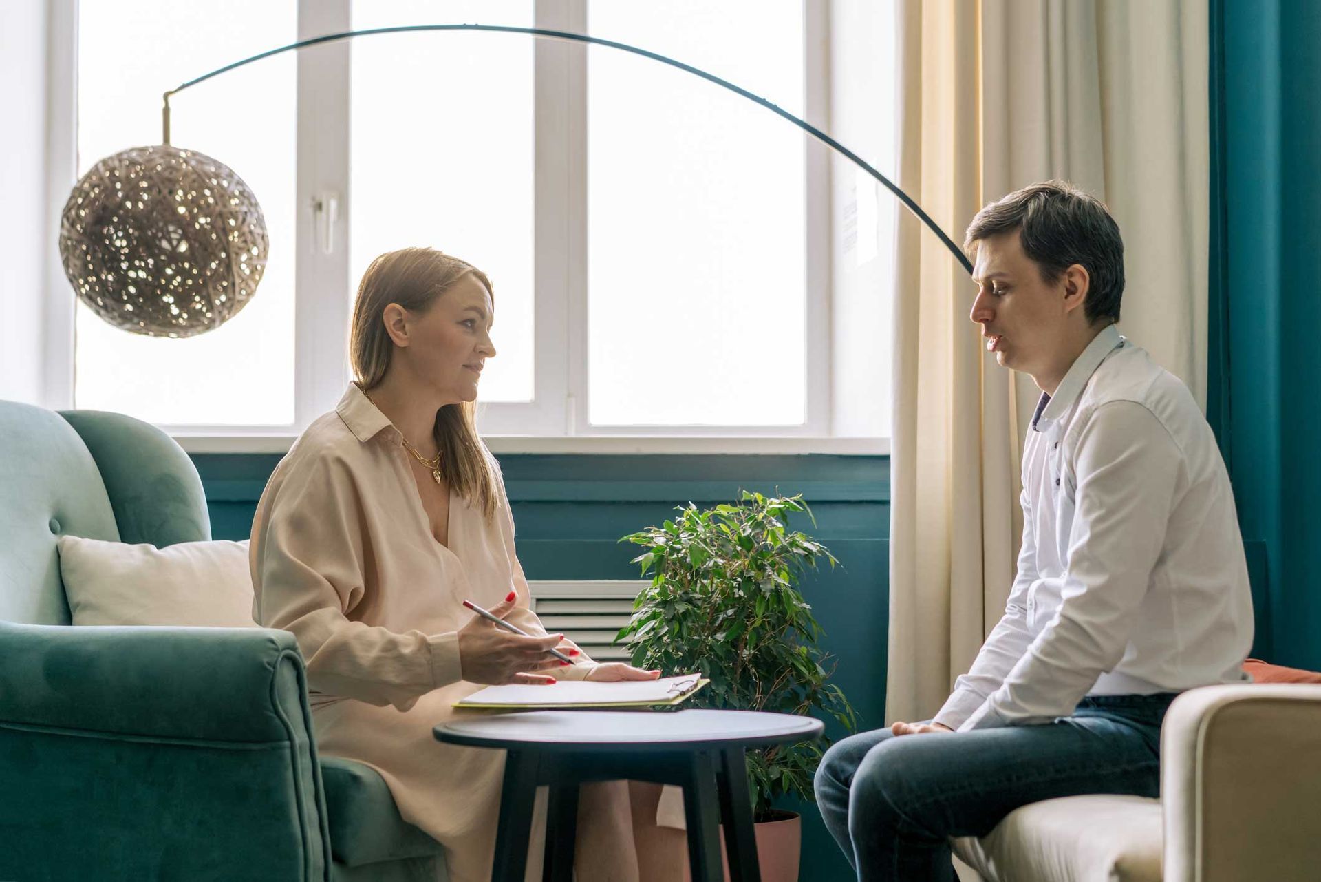 A woman is sitting at a table talking to a man.