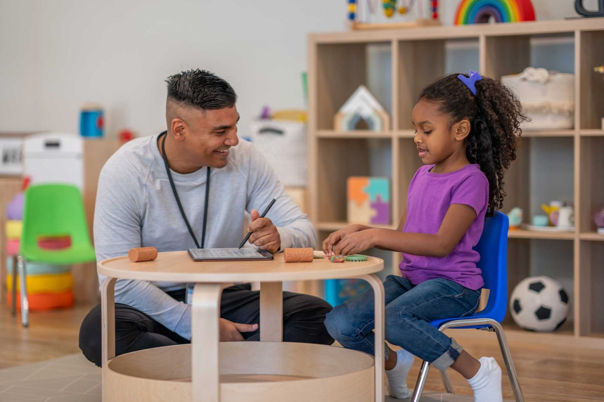 A man is sitting at a table with a little girl.