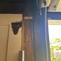 Wooden door frame with a dark shape and pipe.