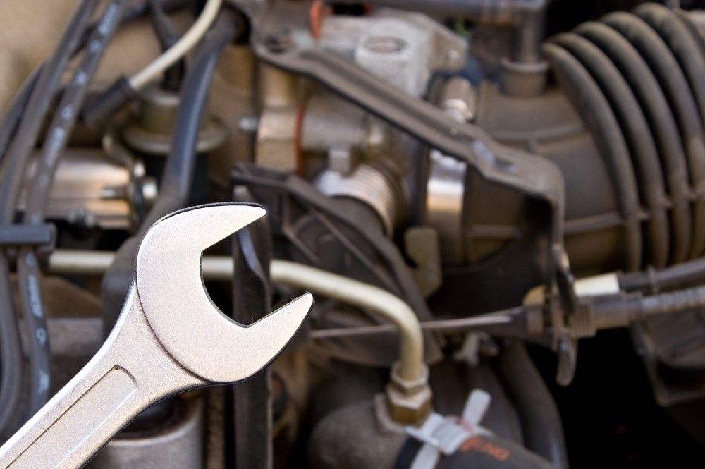 Wrench Held in Front of A Car Engine, Suggesting Repair or Maintenance — Ryders Garage in Erina, NSW