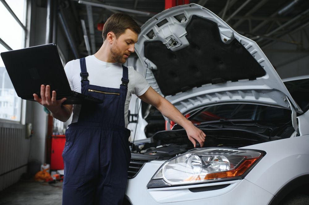 Mechanic Using a Laptop, Inspecting a Car Engine in a Garage — Ryders Garage in Saratoga, NSW