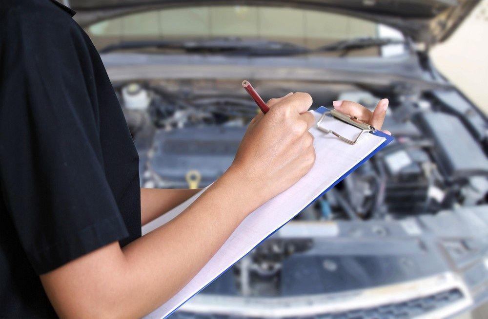 Mechanic Writing on Clipboard While Inspecting a Car Engine — Ryders Garage in Saratoga, NSW