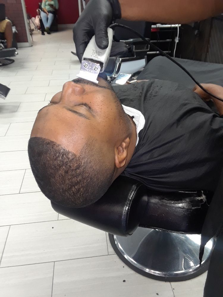 A man is getting his hair cut at a barber shop