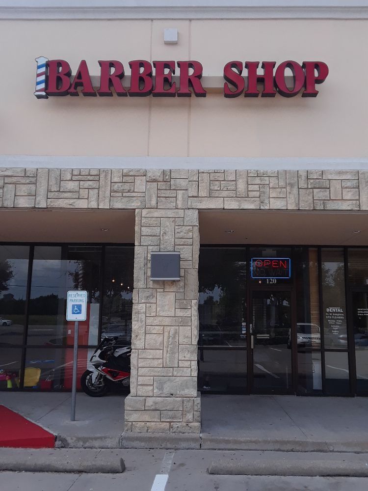 A barber shop with a motorcycle parked in front of it