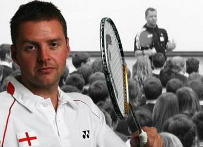 A man holding a tennis racquet in front of a crowd