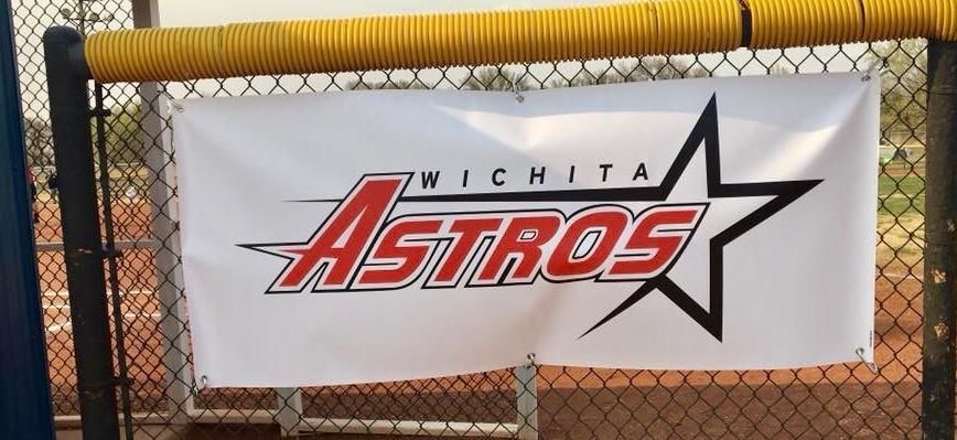 Wichita Astros banner on a chain-link fence with a yellow top rail