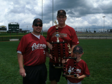 Three people in Astros shirts posing on a baseball field, holding a glove and ball