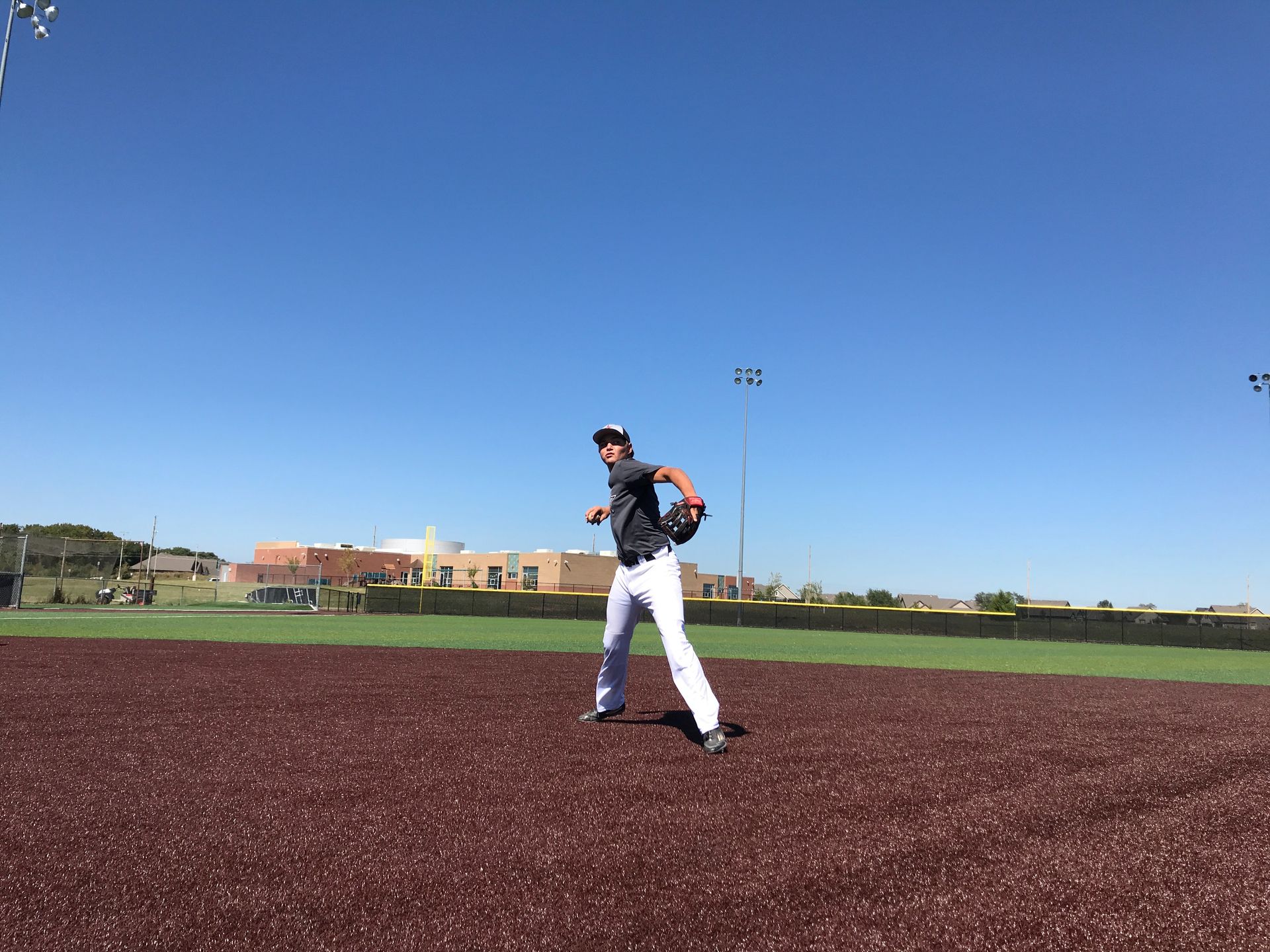 Baseball player standing on a field under a clear blue sky