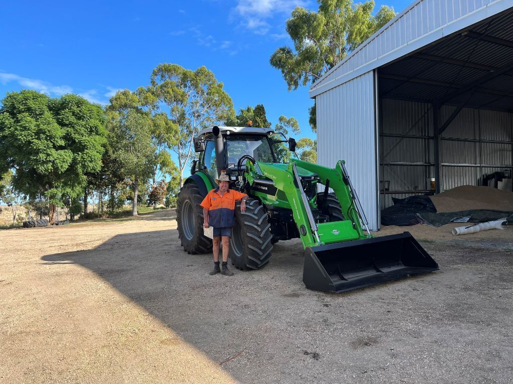 Man Standing Beside Deutz Fahr Tractor — North Coast Construction Equipment In Coffs Harbour, NSW