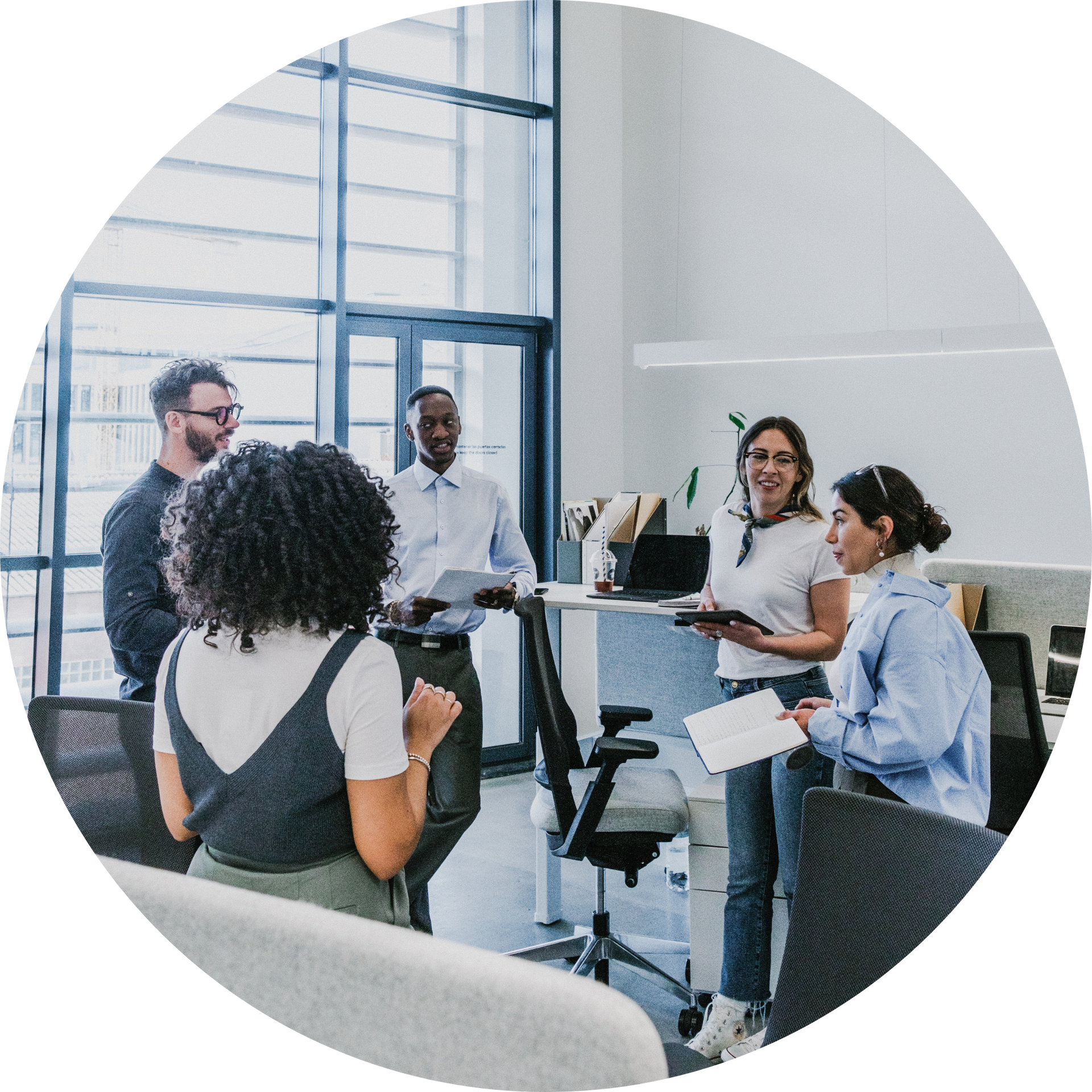 A group of people are standing around in an office.