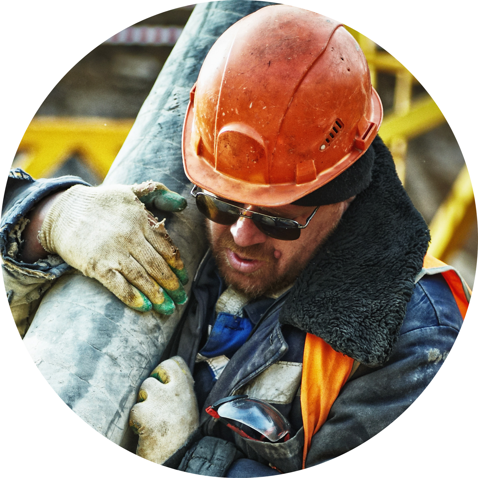 A man wearing a hard hat and sunglasses is holding a pipe