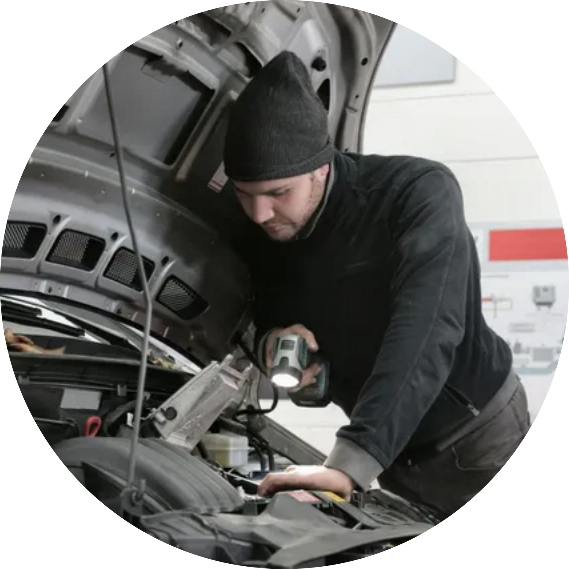 A man is working on the engine of a car with the hood open.