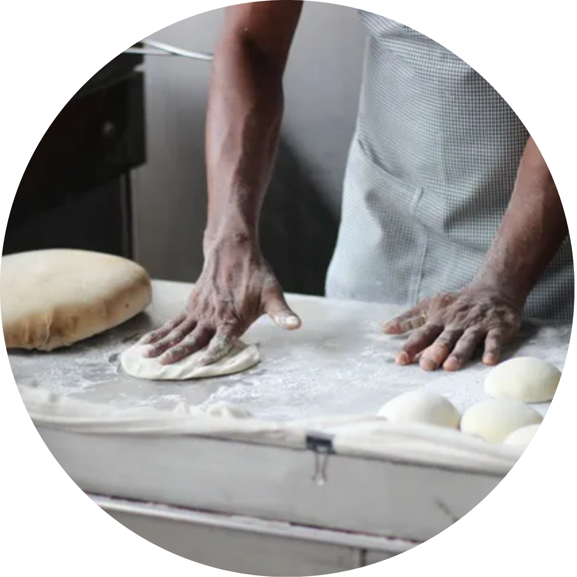 A person is kneading dough on a counter in a kitchen.