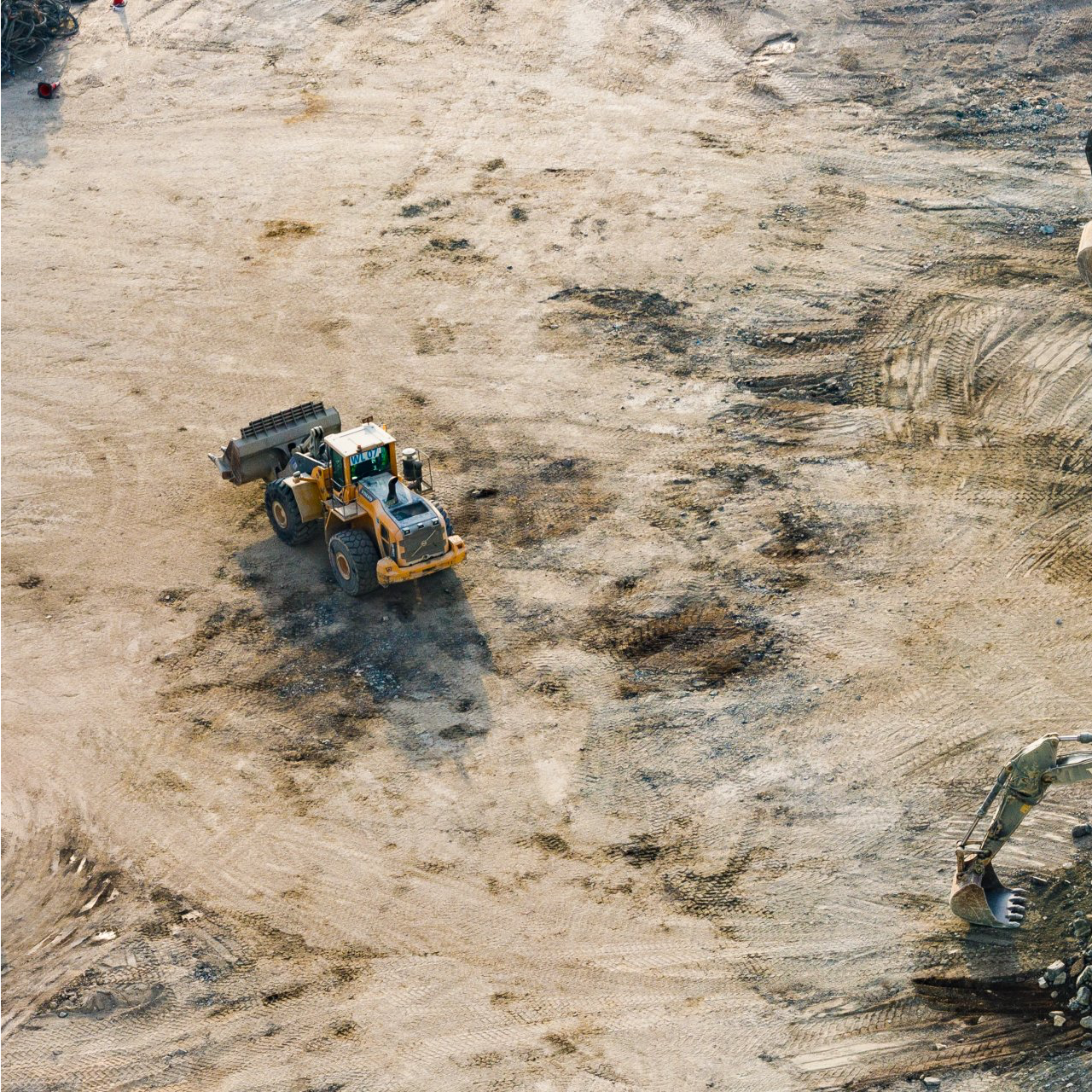 An aerial view of a construction site with a bulldozer and an excavator